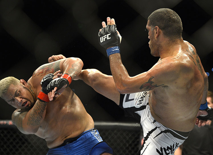 Mark Hunt (left) blocks an a high kick from Antonio Silva.