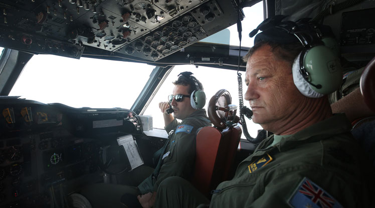 RAAF servicemen in an Orion aircraft looking for signs of the missing plane.