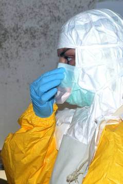 A member of Doctors Without Borders puts on protective gear at Donka Hospital.