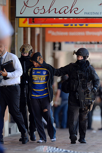 Police take a man into custody at the scene.