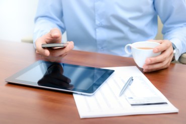 person multitasking coffee ipad phone