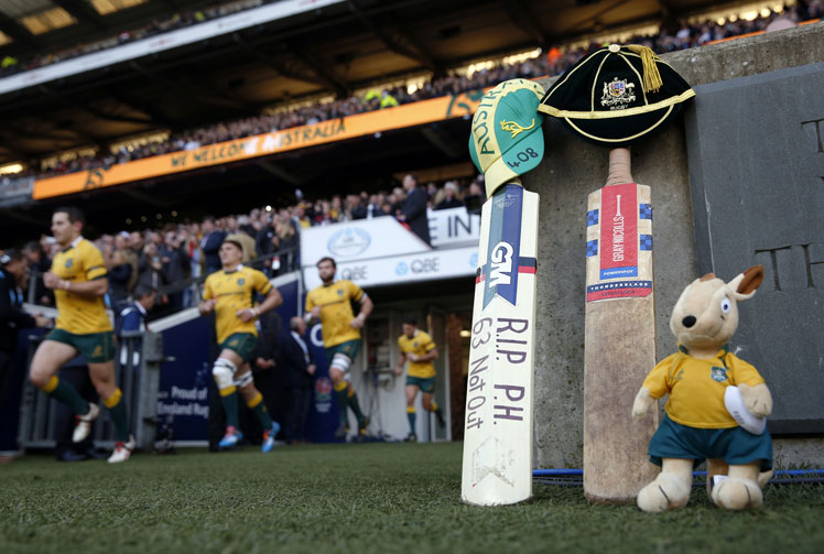 The Wallabies run on to the pitch beside a cricket bat and Australian mascot for the rugby Test against England at Twickenham. Photo: Getty