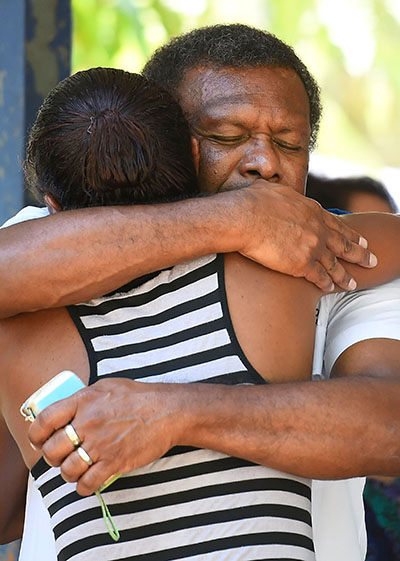Mourners embrace at the makeshift shrine in Cairns. Photo: AAP