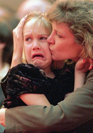 Nancy Schultz comforts her daughter Danielle, 6, at her husband Mark's memorial service in February 1996. Photo: AAP