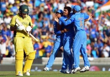 India's Umesh Yadav celebrates with teammates Suresh Raina and Ravindra Jadeja after dismissing Aaron Finch. Photo: Getty