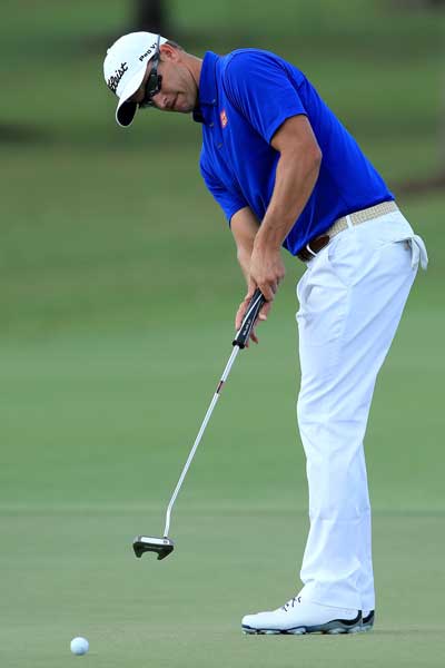 Adam Scott tries out his new putter. Photo: Getty
