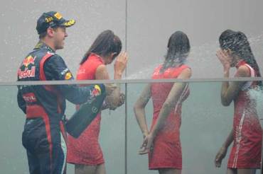 Sebastian Vettel and the podium girls having a laugh after a 2012 victory. Photo: Getty