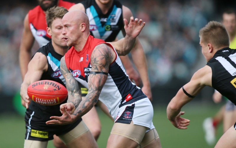 Nathan Jones of Melbourne gets a hand ball away in front of Brad Ebert of Port Adlelaide. Photo: AAP