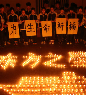 Students light candles and pray for victims of the capsized ship.