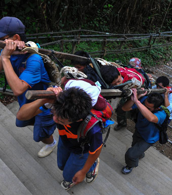 Malaysian rescue team carrying an injured Singaporean student after the quake.