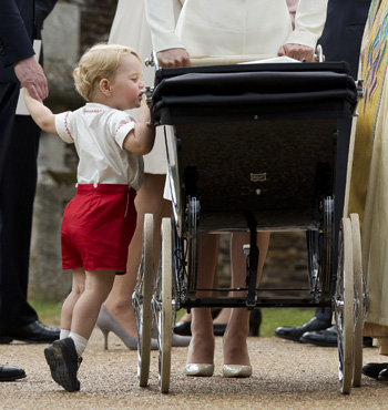 Prince George peeks at sister Princess Charlotte.