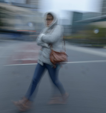 A woman rugs up as she walks through Melbourne.,