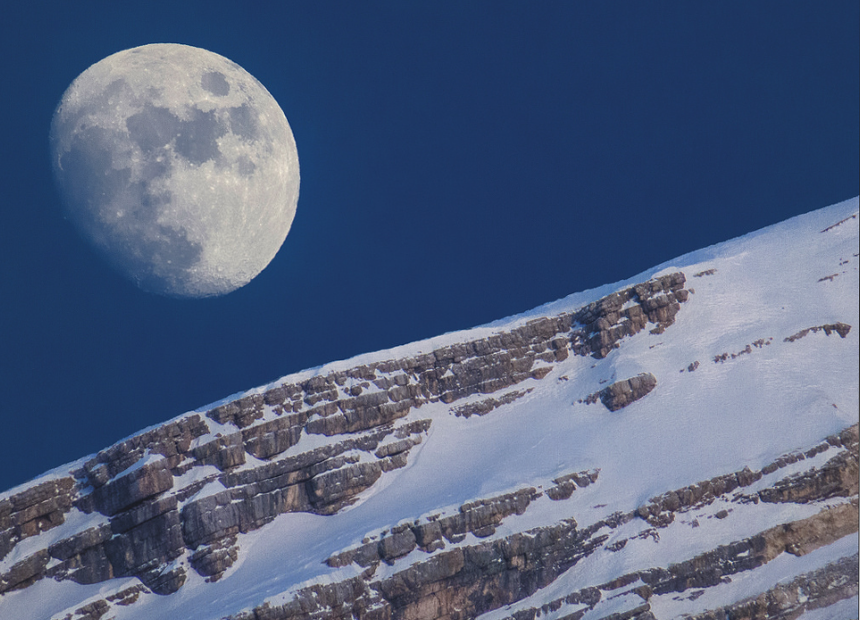 Late afternoon at San Vito di Cadore, Italy the moon shines over Monte Antelao. 