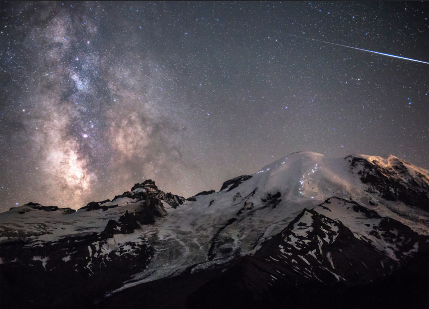  A meteor can be seen piercing through the darkness as the Milky Way towers above the 4,392m peak of Mount Rainier in Washington, USA. 