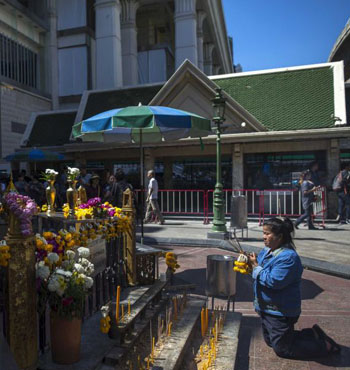 A woman pays her respects at the Erawan shrine.