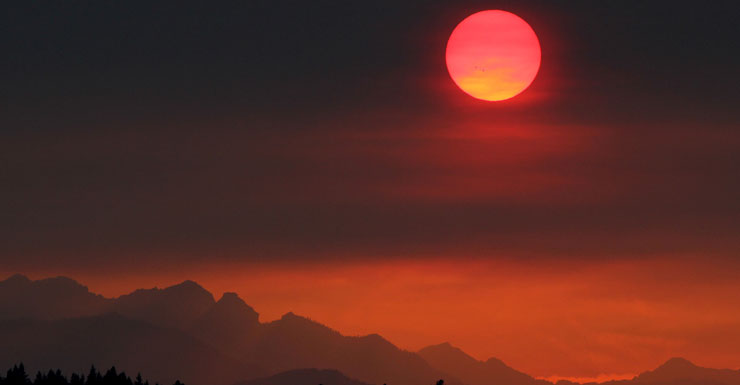 The sun turns red as it sets through smoke from the Washington fires. This photo was taken at the Olymic Mountians in Bremerton. Photo: AAP
