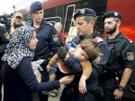 Policemen help children and mothers to board a train in Austria.