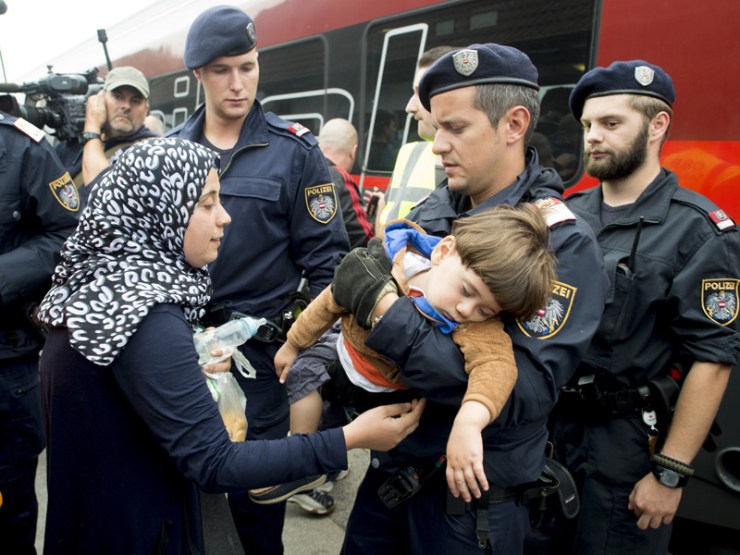 Austrian policemen are helping children and mothers to board a train in the Austrian village of Nickelsdorf.