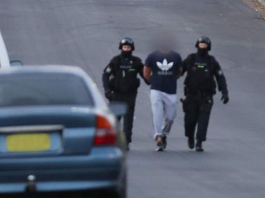 NSW Police lead suspects away after raids in Sydney.