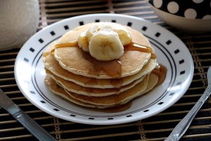 Close-Up Of Pancakes With Banana In Plate On Table