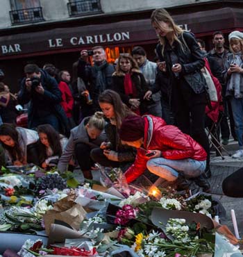 Mourners leave candles in front of the Petit Cambodge restaurant near the Le Carillon restaurant where attacks took place.