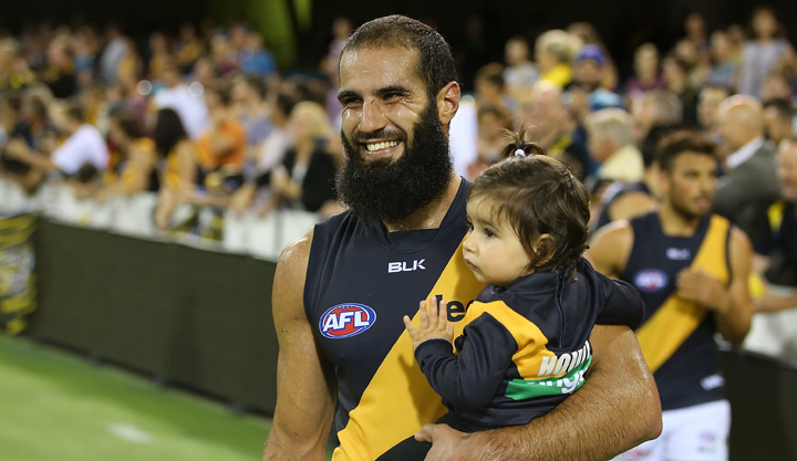 A grinning Houli brings his daughter onto the ground after beating Brisbane in round 18. Photo: Getty