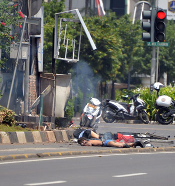 Bodies lie on the street next to a damaged police post in Jakarta.