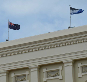The current NZ flag flies alongside its possible replacement atop the Wellington town hall.