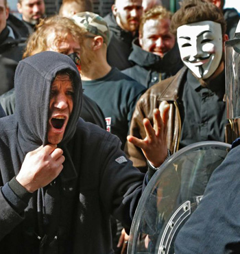 Police used a water cannon against a group that burst onto the vigil shouting anti-migrant slogans.