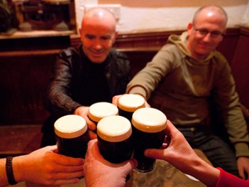 Men holding glasses of stout