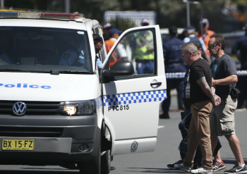 A man is led away from the scene by officers. He allegedly hindered police.Photo: AAP