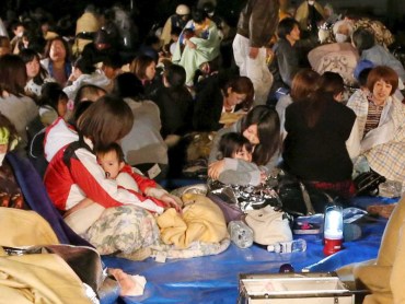 Evacuees gather in front of the town office building after escaping homes after the earthquake struck.