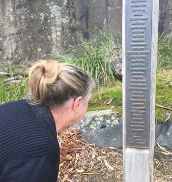 Lynne Beavis reads the names on the memorial commemorating the 35 people who were killed.
