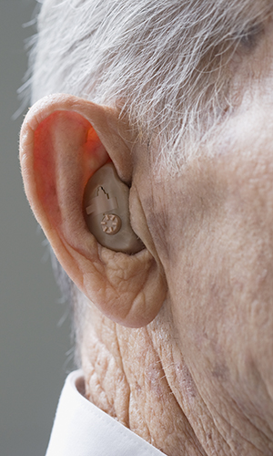 Close up of senior Hispanic man’s hearing aid