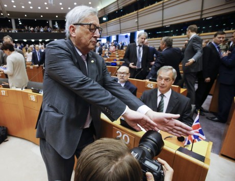 European Commission President Jean- Claude Juncker tries to block a photographer's view on Nigel Farage. Photo: AAP