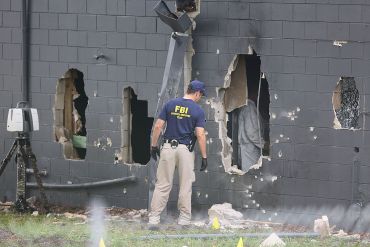 FBI agents investigate the damaged rear wall of the Pulse Nightclub. Photo: Getty.