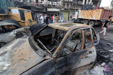 People gather at the site of a suicide car bomb attack in central Baghdad. Photo: AAP