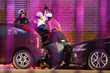 Dallas Police shield bystanders after shots were fired at the protest. Photo: AAP