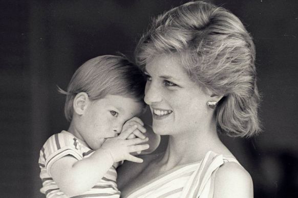 Prince Harry tries to hide behind his mother during a morning picture session in August 1988.
