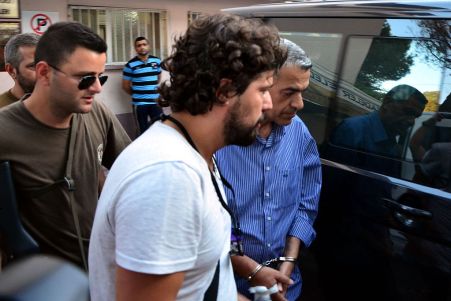A garrison commander (R) is taken into custody. Photo: Getty.
