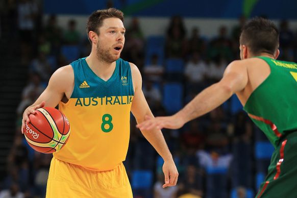 Matthew Dellavedova #8 of Australia looks to drive the ball against Mantas Kalnietis.
