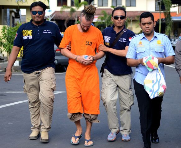 Detained British national David Taylor (2nd L) escorted by Indonesian police.