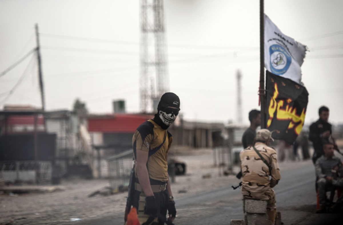 An Iraqi soldier in a skull mask waits at a checkpoint for people fleeing the city of Mosul. Photo: Getty