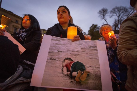 A woman holds a picture of Aylan Kurdi during a 2015 remembrance vigil in Melbourne.