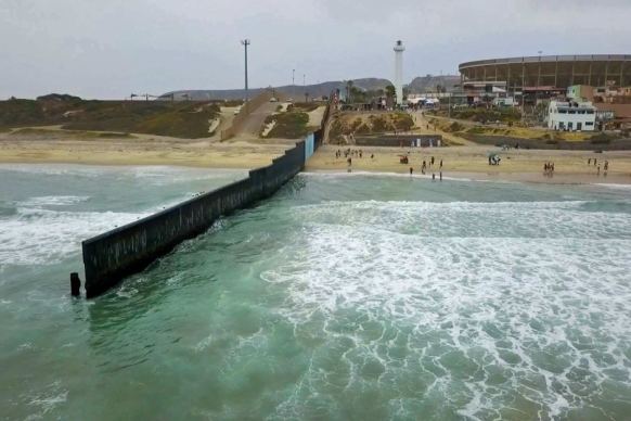 The fence separating the US from Mexico juts into the Pacific Ocean