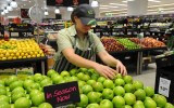 An employee arranges fruit inside a Woolworths grocery store