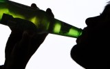 A person drinking a bottle of beer