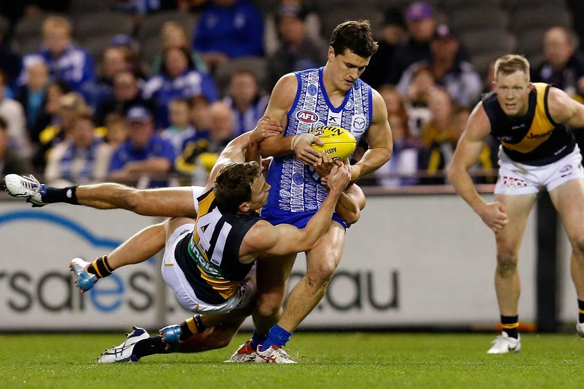 Scott Thompson fights off the attention of Nathan Foley.