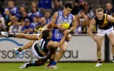 Scott Thompson fights off the attention of Nathan Foley.