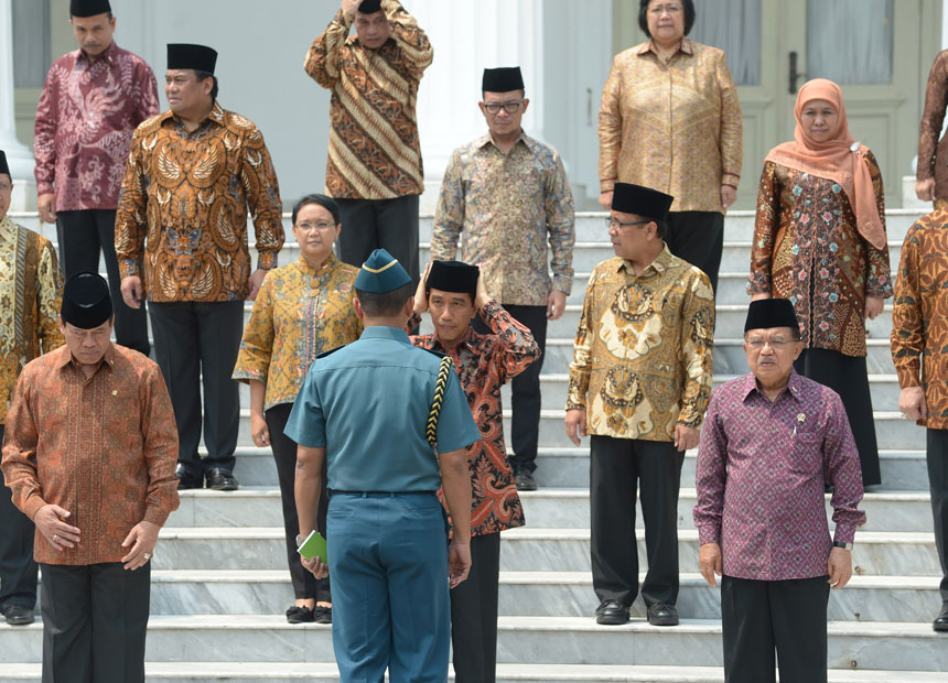 Indonesian President Joko Widodo adjusts his Muslim cap in front of his new cabinet.